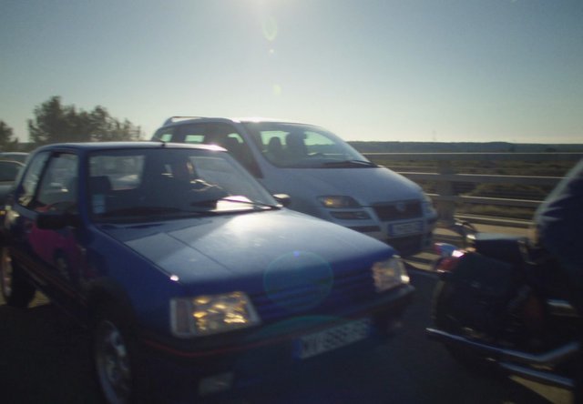 Video Reference: cars, road, traffic, sunlight, lens flare, driving, highway, vehicles, daytime, blurred, outdoor, transportation