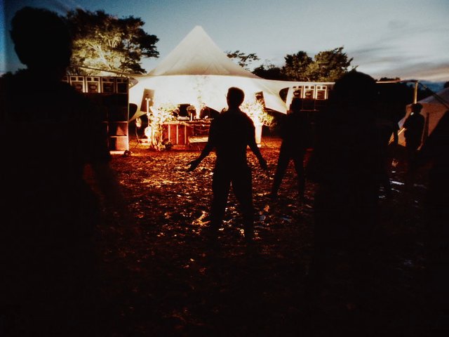 Video Reference: outdoor, tent, dusk, silhouette, people, event, camping, night, lighting, trees, mud, gathering, festival