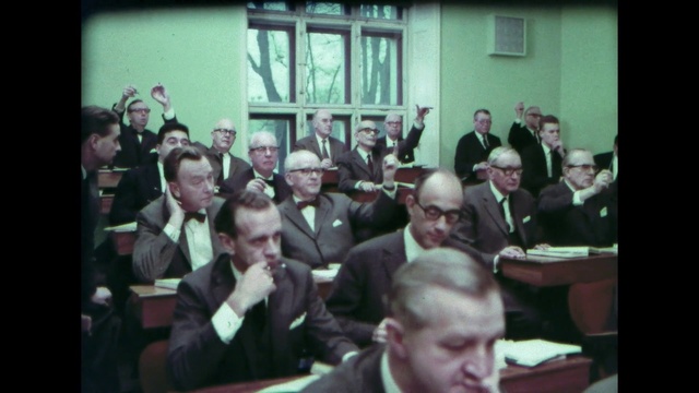 Video Reference: Glasses, Window, Coat, Tie, Suit, Crowd, Event, White-collar worker, Team, Room
