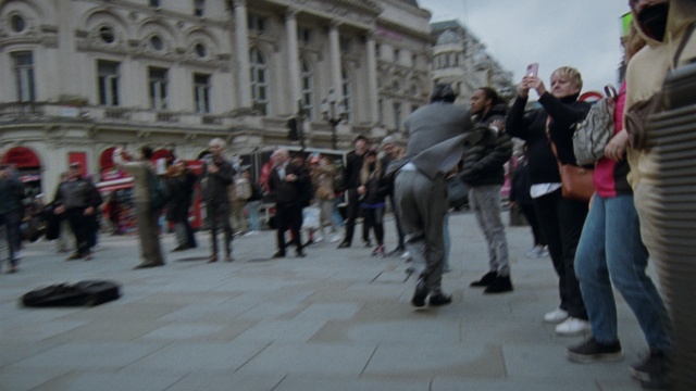 Video Reference: Building, Standing, Public space, City, Crowd, Event, Human settlement, Pedestrian, Tourism, Street