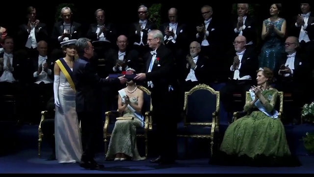 Video Reference: Hat, Chair, Suit, Formal wear, Event, Official, Military uniform, Uniform, Fashion design, Gown