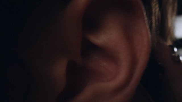 Video Reference: ear, close-up, face, human skin, low light, out of focus, blurred, macro, portrait, indoor, dark, partial view