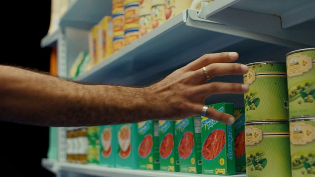 Video Reference: grocery, supermarket, shelf, canned goods, hand, shopping, retail, food aisle, close-up, product display, store, consumer