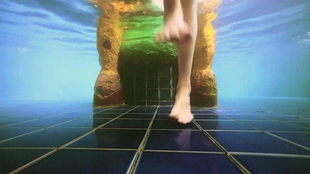Video Reference: underwater, swimming pool, legs, feet, motion, tiled floor, submerged, water, pool entrance, statue, blue, sport, recreation, aquatic, perspective