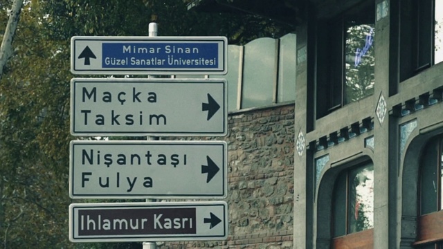 Video Reference: Motor vehicle, Font, Window, Landmark, Street sign, Gas, Signage, Road, Traffic sign, Tree