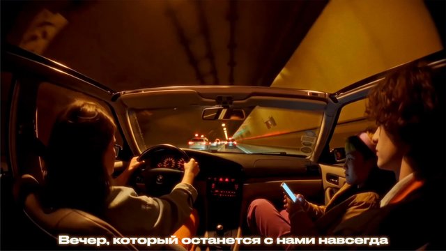 Video Reference: car interior, tunnel, night drive, travel, passengers, driver, rear seat, mobile phone, city road, dim lighting, interior view, road trip, evening, overlay text