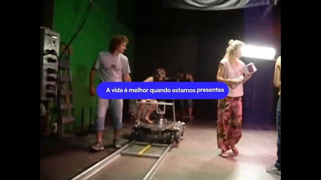 Video Reference: studio, behind the scenes, film set, crew, camera dolly, lighting, green screen, production, people, Portuguese text, overlay, indoor, set design, video shoot