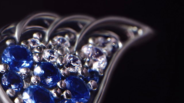 Video Reference: jewelry, gemstone, heart shape, macro, close up, blue stones, diamonds, sparkle, luxury, accessory, ring, pendant, shiny, elegant, dark background