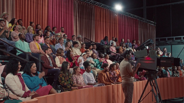 Video Reference: Chair, Suit, Community, Crowd, Event, Curtain, T-shirt, Audience, Tripod, Public speaking