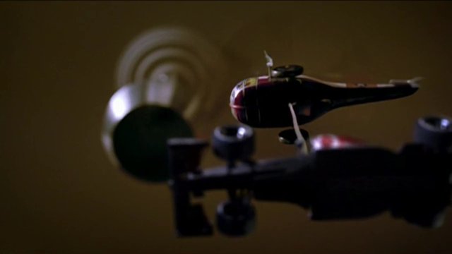 Video Reference: toy, helicopter, model, close-up, blurred, indoor, macro, aircraft, plaything, background, shallow depth of field