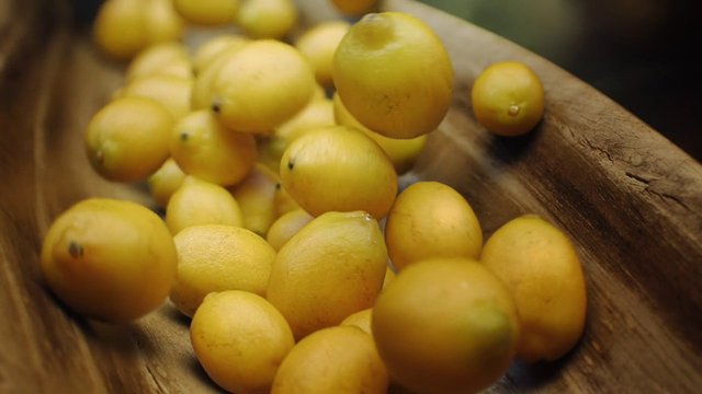 Video Reference: citrus, fruit, yellow fruit, lemons, close-up, wooden bowl, fresh produce, food, market, harvest, organic, natural, still life