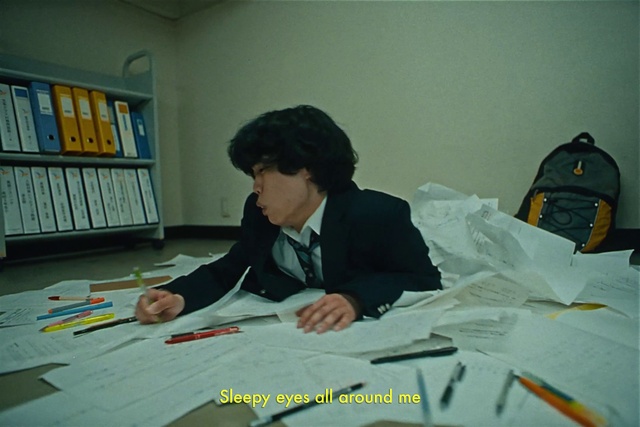 Video Reference: Building, Table, Flooring, Writing implement, Desk, Comfort, Publication, Bookcase, Job, Writing