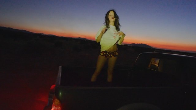 Video Reference: sunset, dusk, person, pickup truck, truck bed, mountains, outdoors, portrait, travel, roadside, evening, silhouette, sky, landscape, casual
