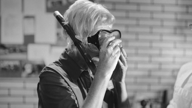 Video Reference: Hand, Photographer, Musician, Camera, Mammal, Black-and-white, Music, Style, Street fashion, Eyewear