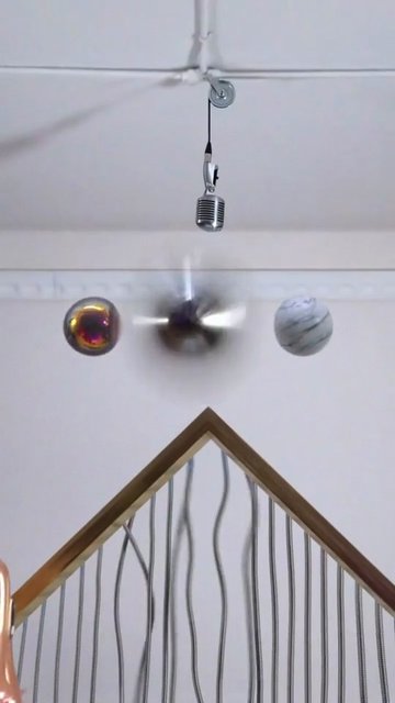 Video Reference: hanging microphone, ceiling, motion blur, indoor, spheres, decorative railing, abstract, vertical frame, interior, minimal scene