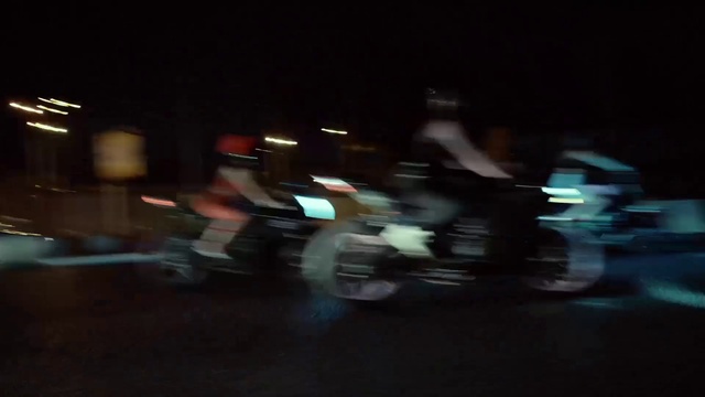 Video Reference: Automotive lighting, Bicycle wheel, Helmet, Sports equipment, Asphalt, Tints and shades, Headlamp, Midnight, Event, Entertainment