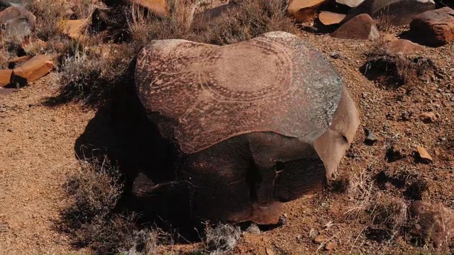 Video Reference: desert, boulder, rock, landscape, arid, scrub, dry terrain, outdoors, nature, stone, sedimentary, wilderness