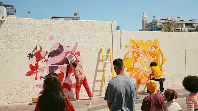 Video Reference: Sky, Temple, Artist, Art, Wall, Leisure, Graffiti, Event, Human settlement, Hat