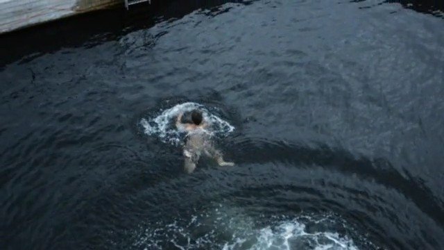 Video Reference: swimmer, swimming, open water, dock, pier, water, aerial, overhead, outdoor, sports, recreation, dark water, waves, motion