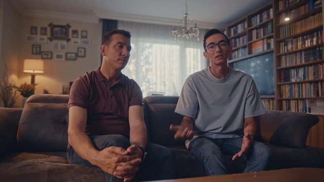 Video Reference: Muscle, Comfort, Eyewear, Flash photography, Shelf, Bookcase, Facial hair, T-shirt, Couch, Fun