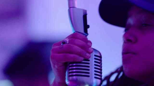 Video Reference: Arm, Drinkware, Purple, Entertainment, Gesture, Violet, Eyelash, Pink, Music artist, Audio equipment